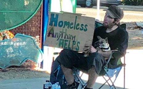Homeless man with sign reading "Homeless Anything Helps"